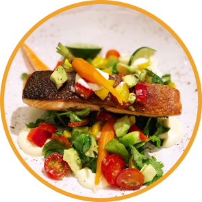 Fresh trout served over locally sourced produce demonstrates the farm to table concept found in restaurants in the Asheville area.